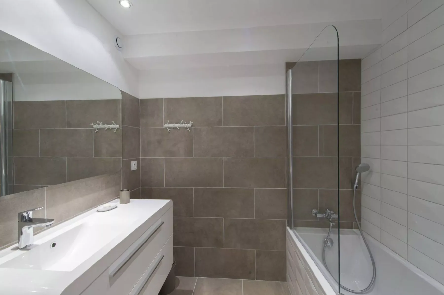 A tiled bathroom with a sink vanity and shower.
