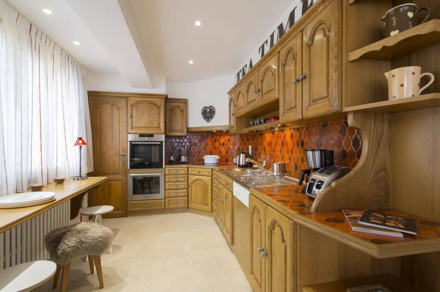 A kitchen with wooden cabinets, an oven, and a tiled backsplash.