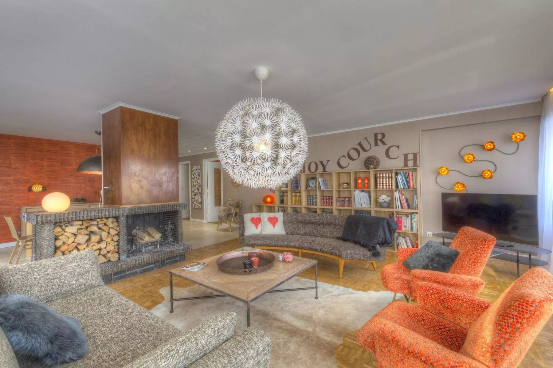 A living room with seating arranged around a coffee table and fireplace.