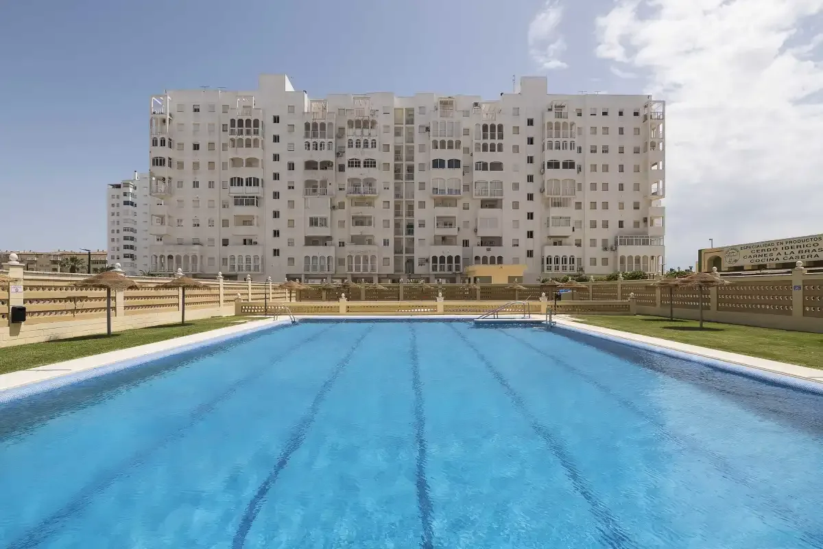 Una piscina frente a un gran edificio de apartamentos.