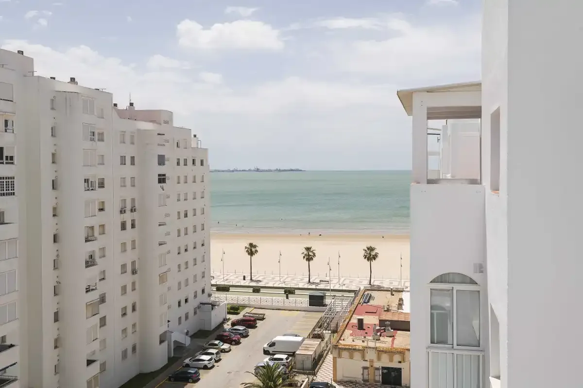 Vista de la playa y el mar entre edificios de apartamentos.