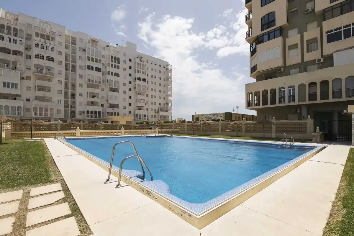 Una piscina al aire libre está entre varios edificios de apartamentos.