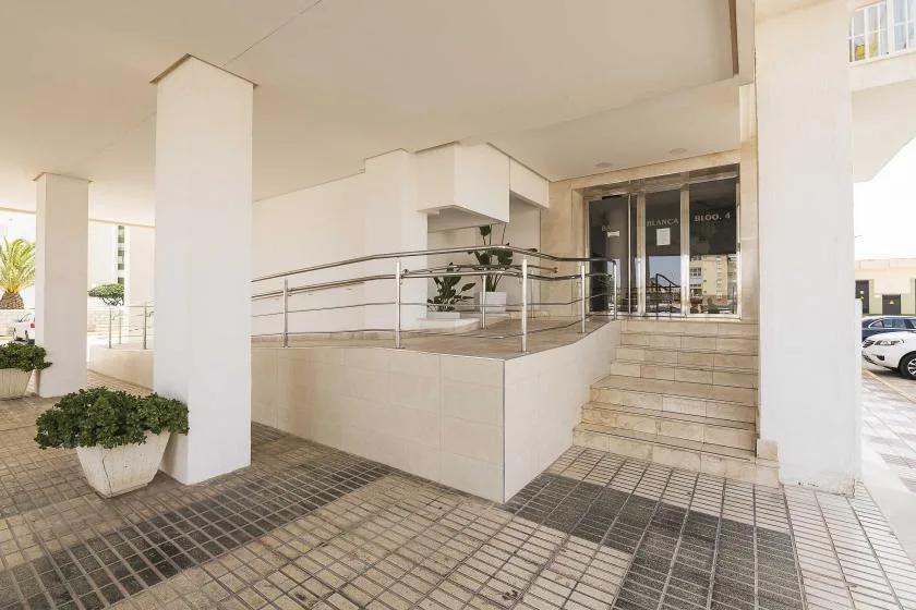 Una entrada cubierta con escalones de baldosas y una barandilla metálica.