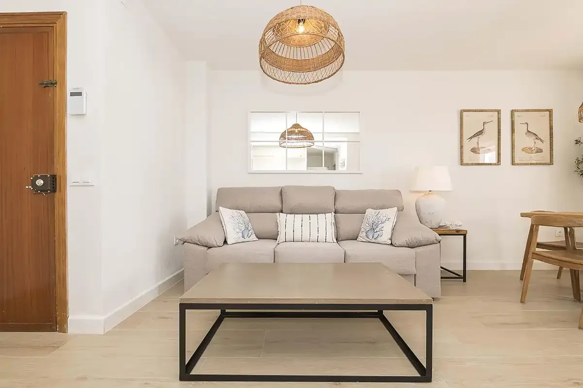 Una sala de estar luminosa con un sofá y una mesa de centro.