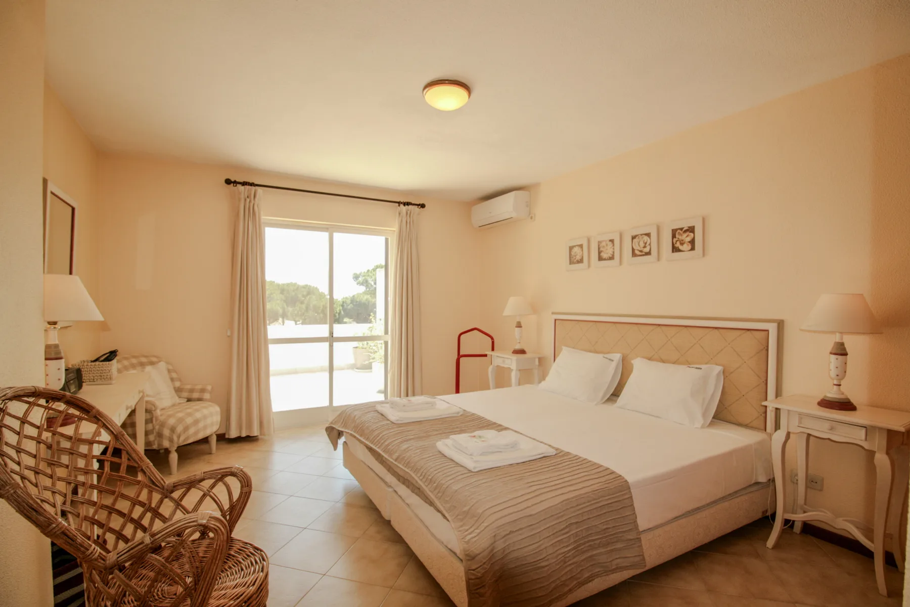 Un dormitorio con una cama grande y una puerta acristalada que da a una terraza.