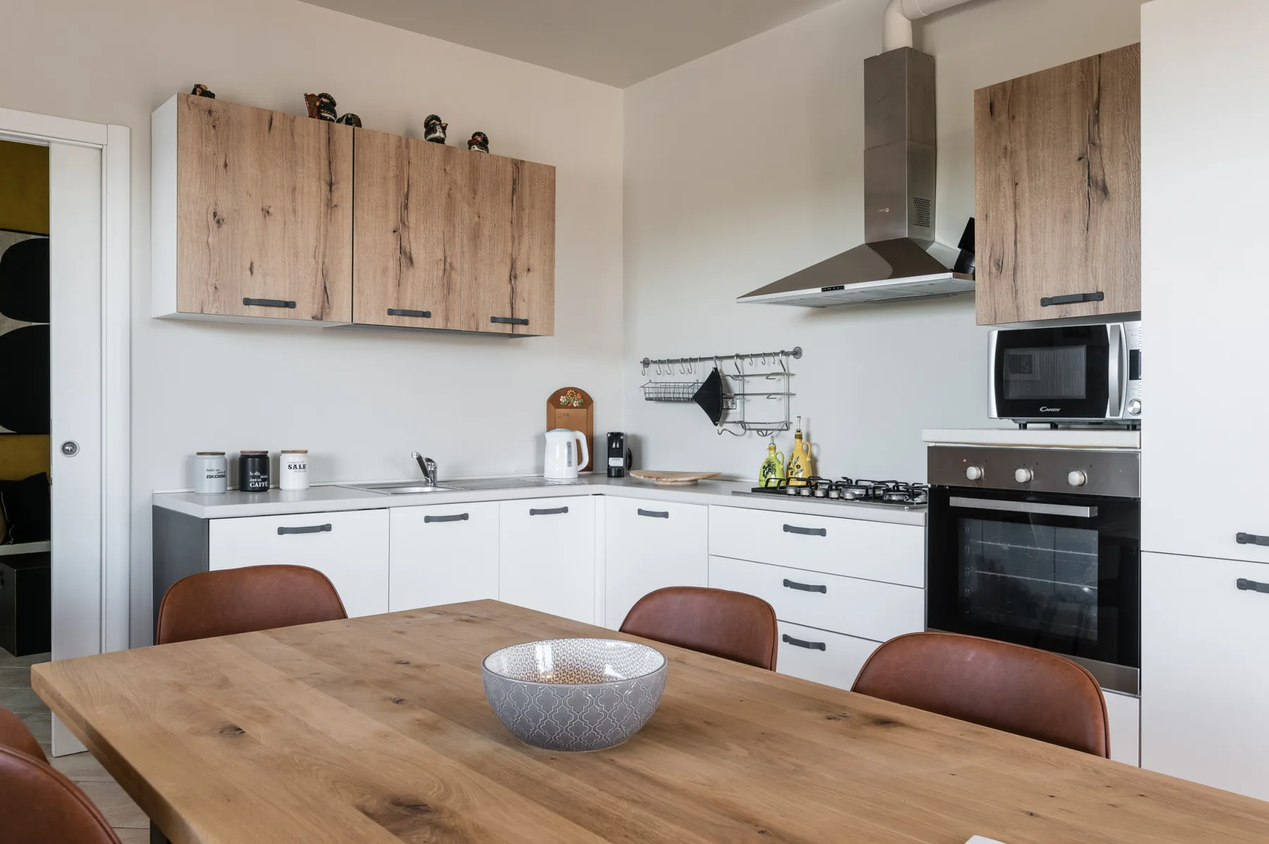 Una cocina moderna con gabinetes de madera, una placa de cocina y una mesa de comedor.
