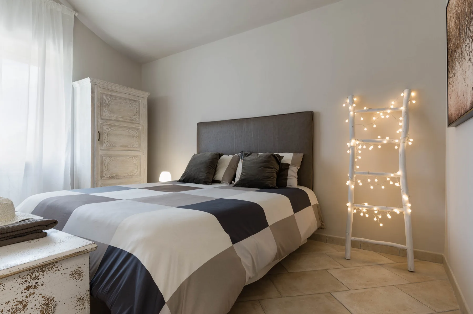 Un dormitorio con una cama y una escalera decorada con luces.