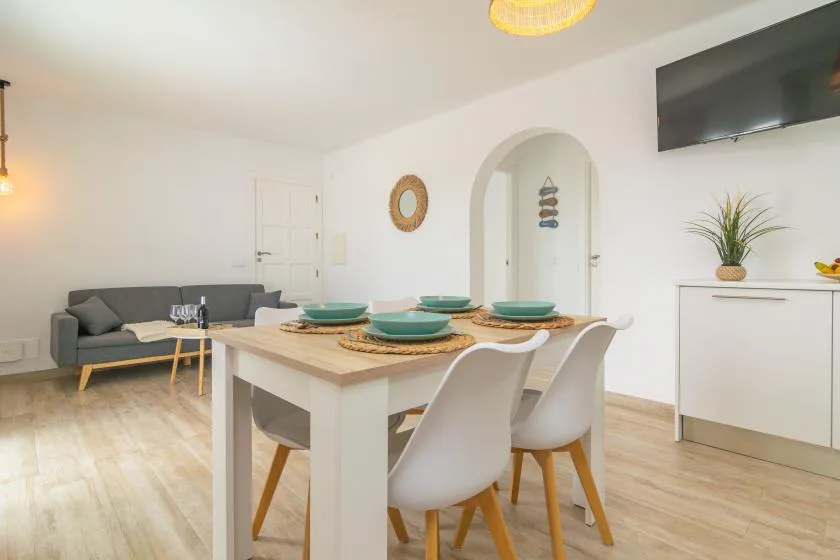 A bright dining area with a set table and a seating area nearby.
