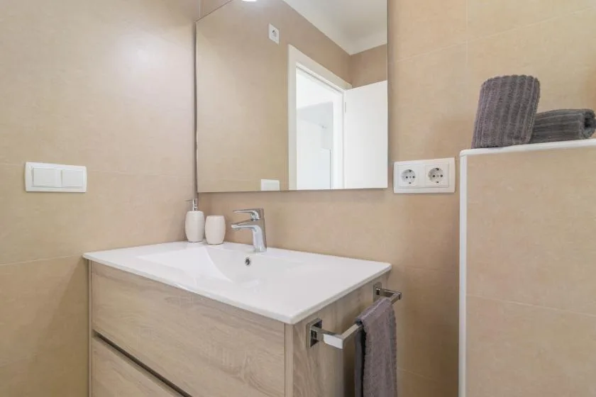 A bathroom vanity with a white sink and mirror.