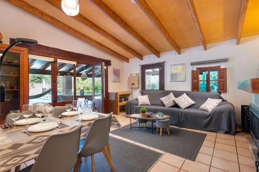 A living and dining area with a gray sofa and a set dining table.