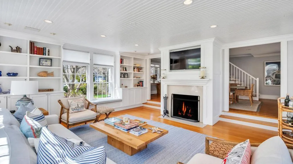 A bright living room with built-in shelves, a fireplace, and seating around a coffee table.