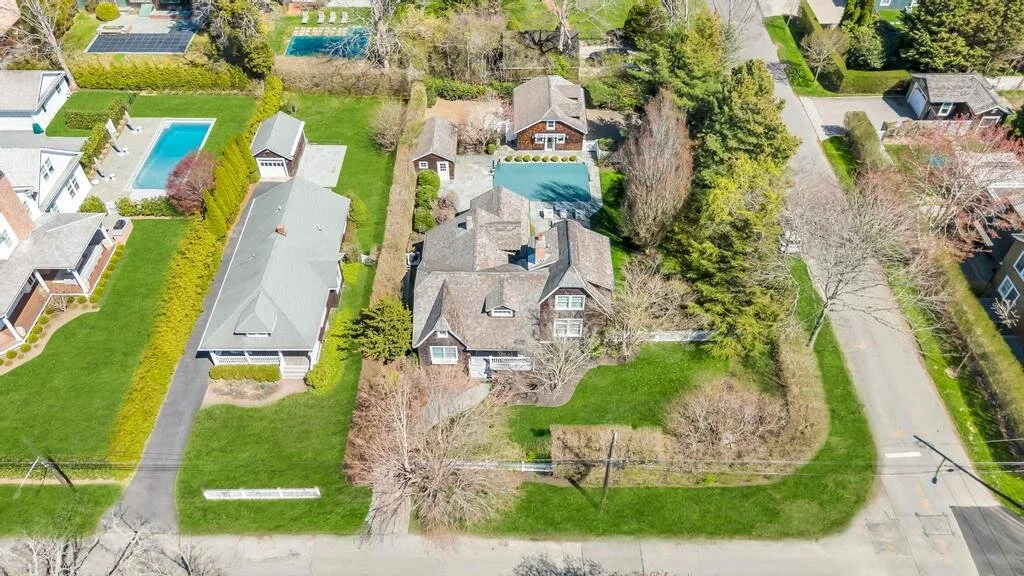 Aerial view of a house and surrounding properties along a residential street.