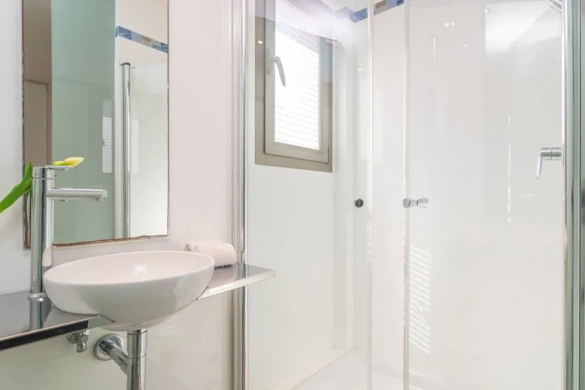A bright bathroom with a glass shower and a vessel sink.