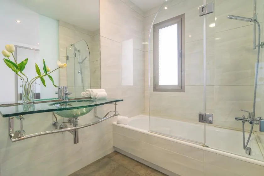 A bright bathroom with a glass-enclosed shower and a sink counter.
