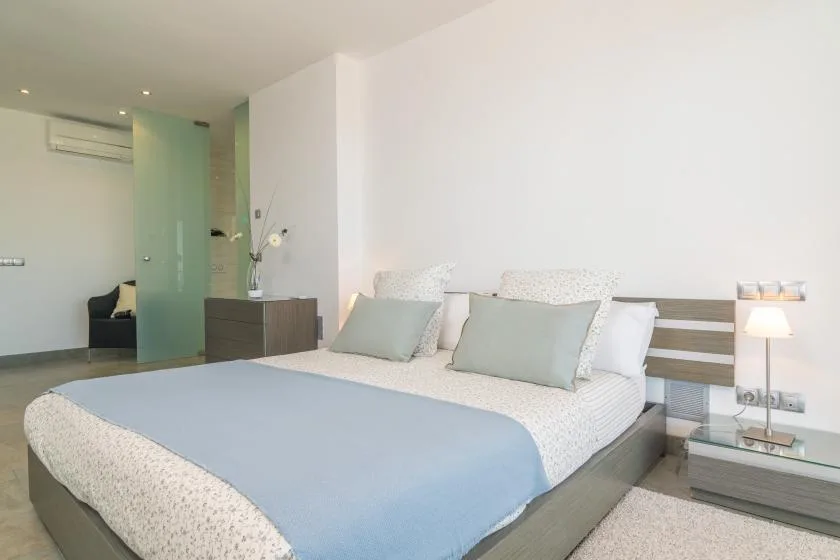 A bedroom with a neatly made bed and pale blue bedding.