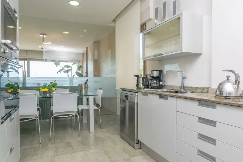 A bright kitchen with a dining table and seating beside the counter.