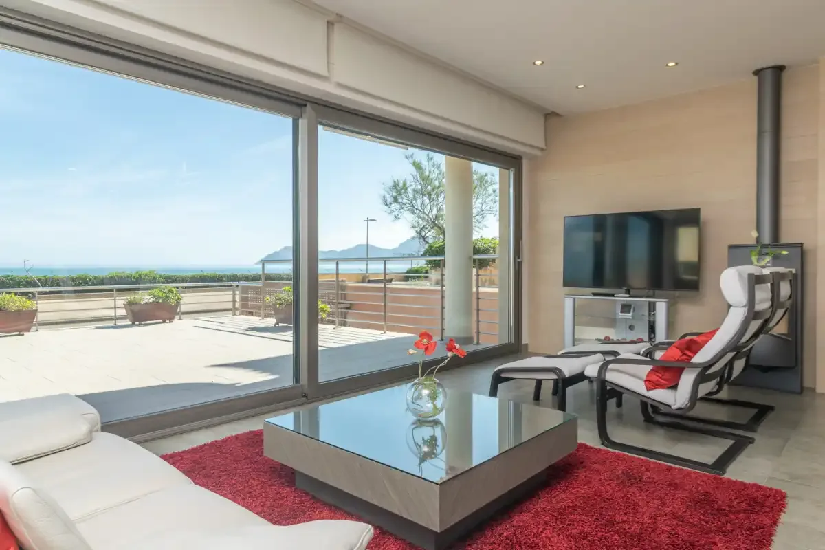 A bright living room with large glass doors opening onto a terrace.