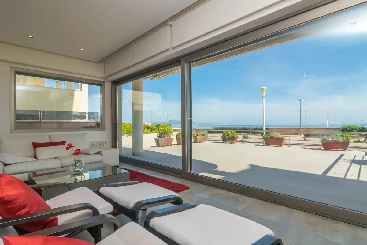 A bright living area opens onto a terrace with views of the sea.