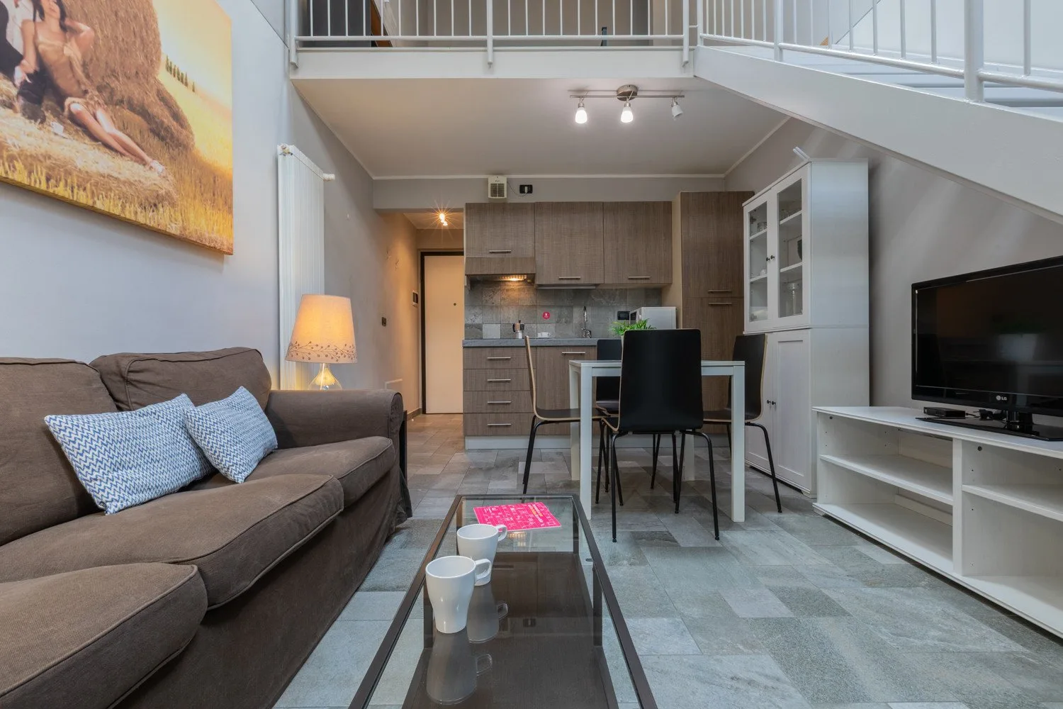 An open-plan living room and kitchen with a dining table and seating.