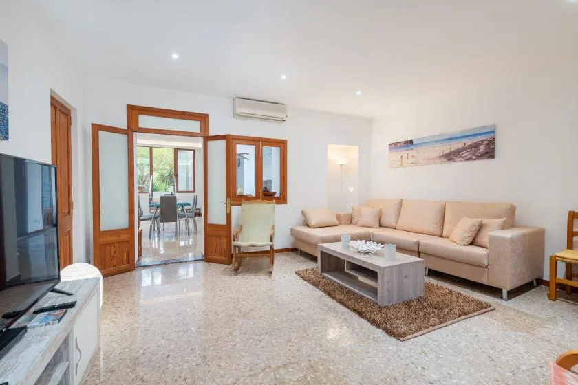 A bright living room with beige seating and a coffee table.