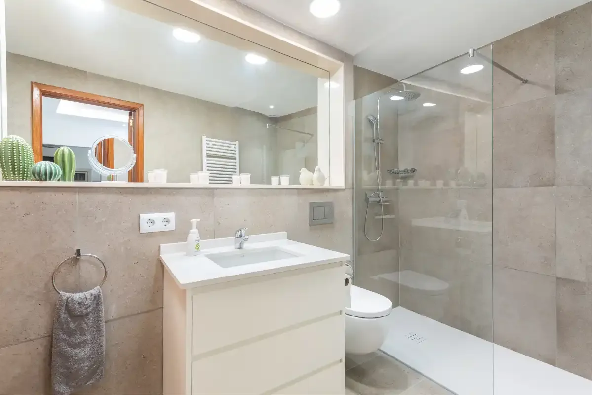 A modern bathroom with a vanity, mirror, and glass shower.