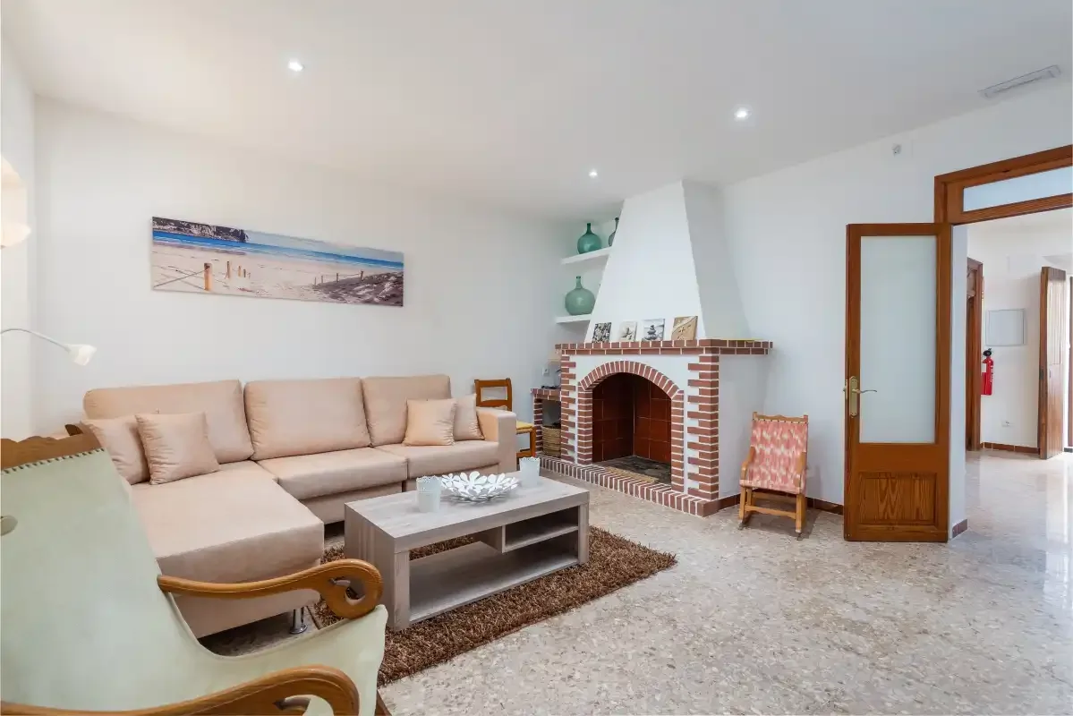 Living room with seating, a coffee table, and a brick fireplace.
