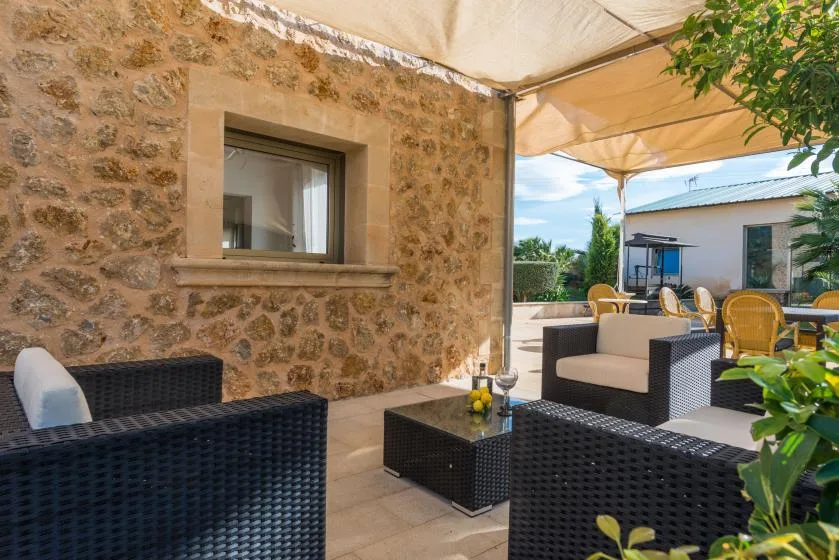 An outdoor seating area with dark woven furniture beneath a canopy.
