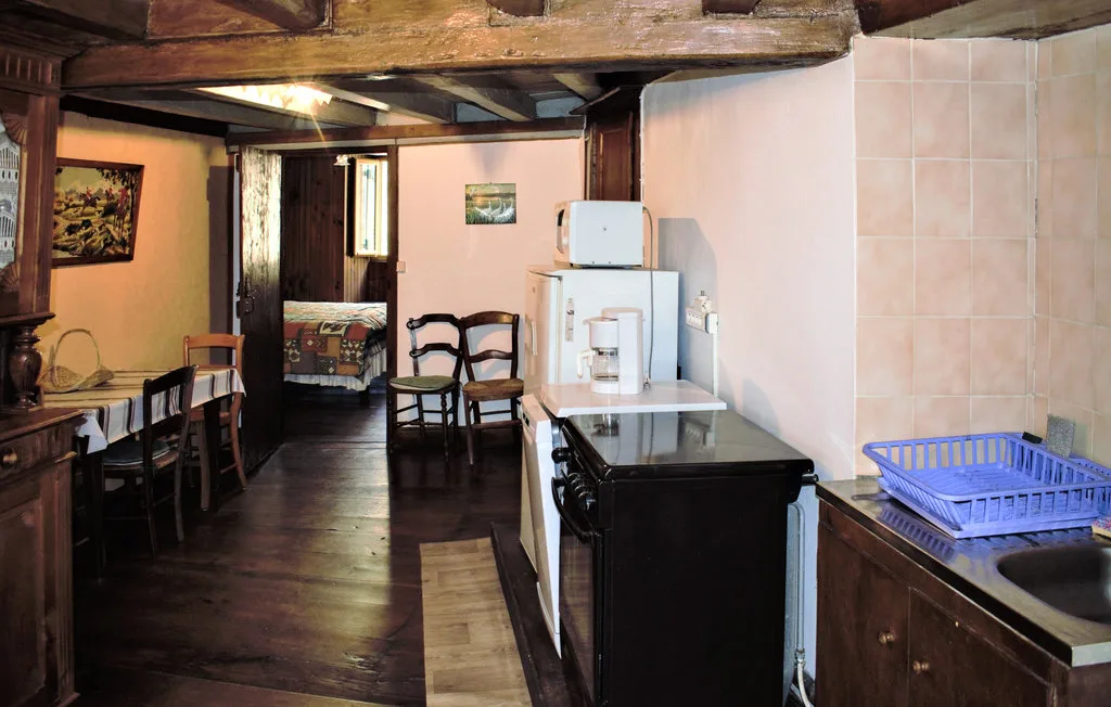 A rustic kitchen with dark wooden cabinetry and a long dining table.