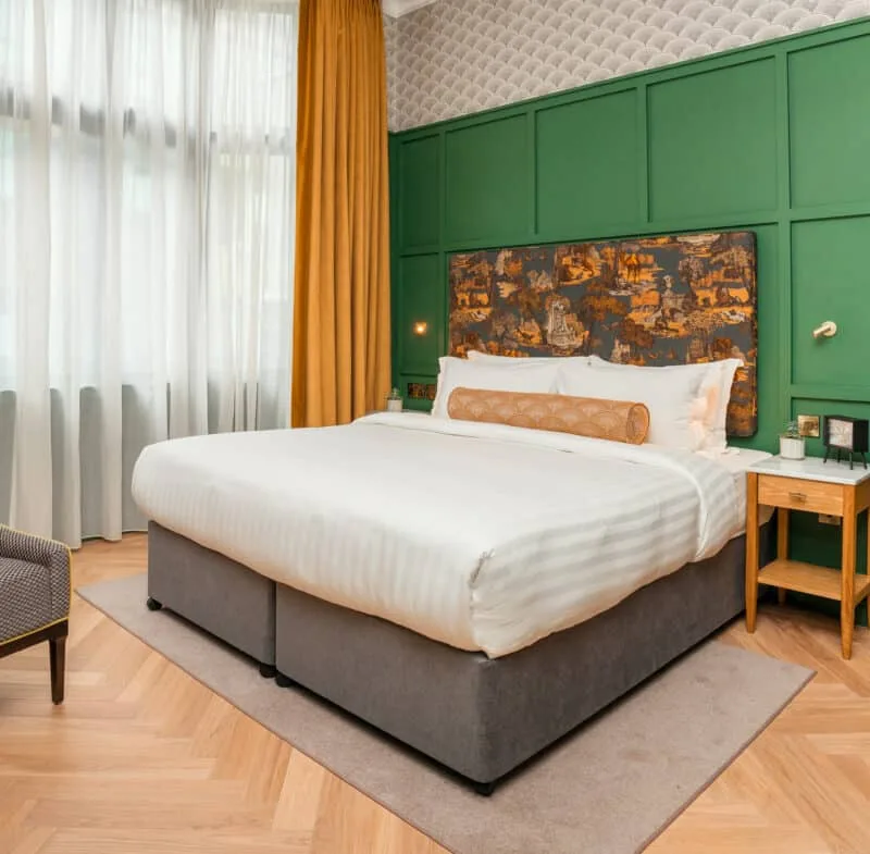 Hotel room with a king-size bed and armchair.