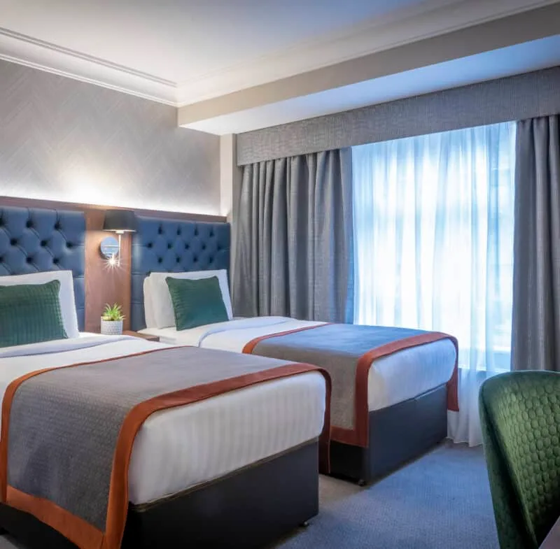 Hotel room with twin beds and a seating area.