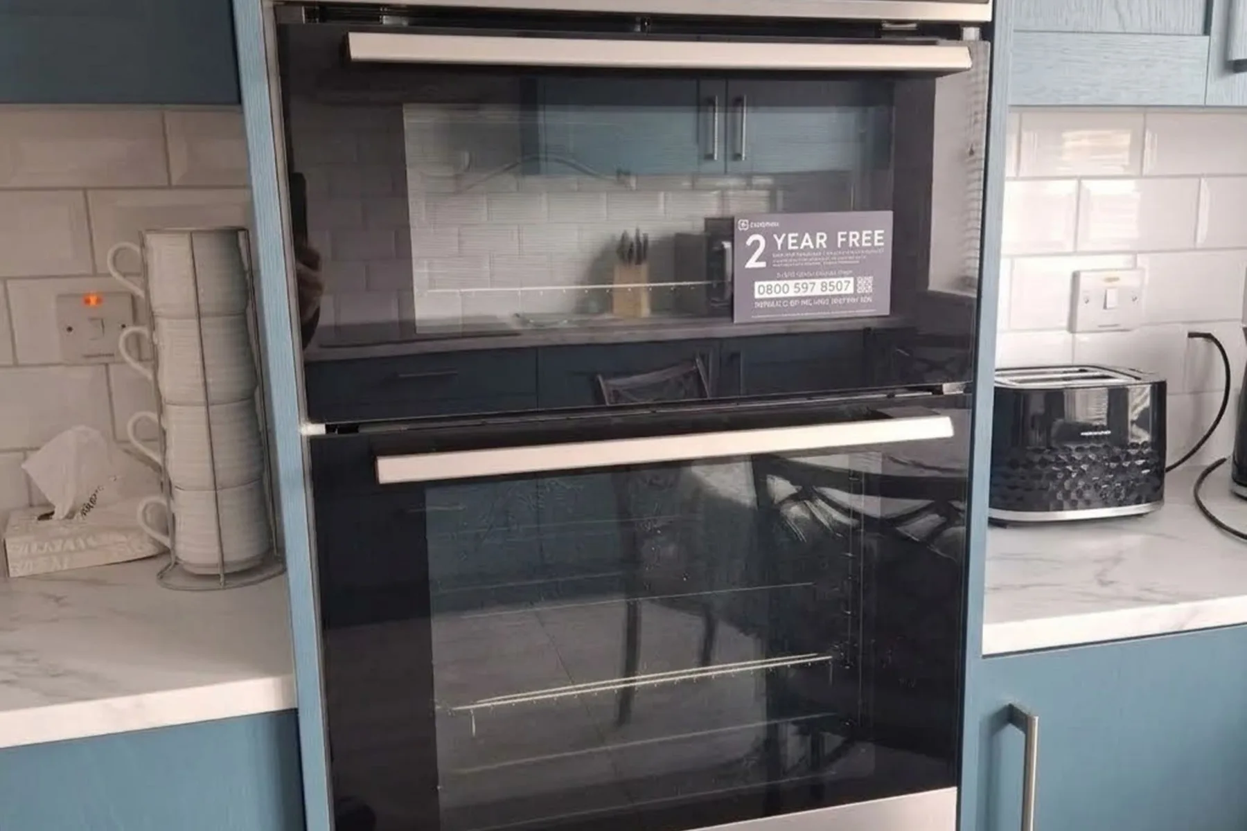 Un horno de cocina está integrado en los armarios debajo de una placa de cocción.
