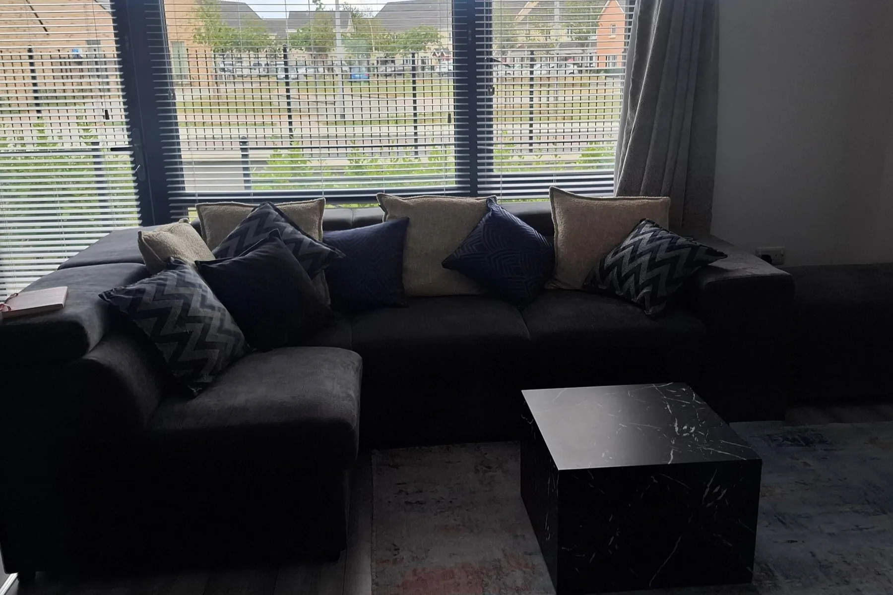 A living room with a dark sectional seating area and a low coffee table.