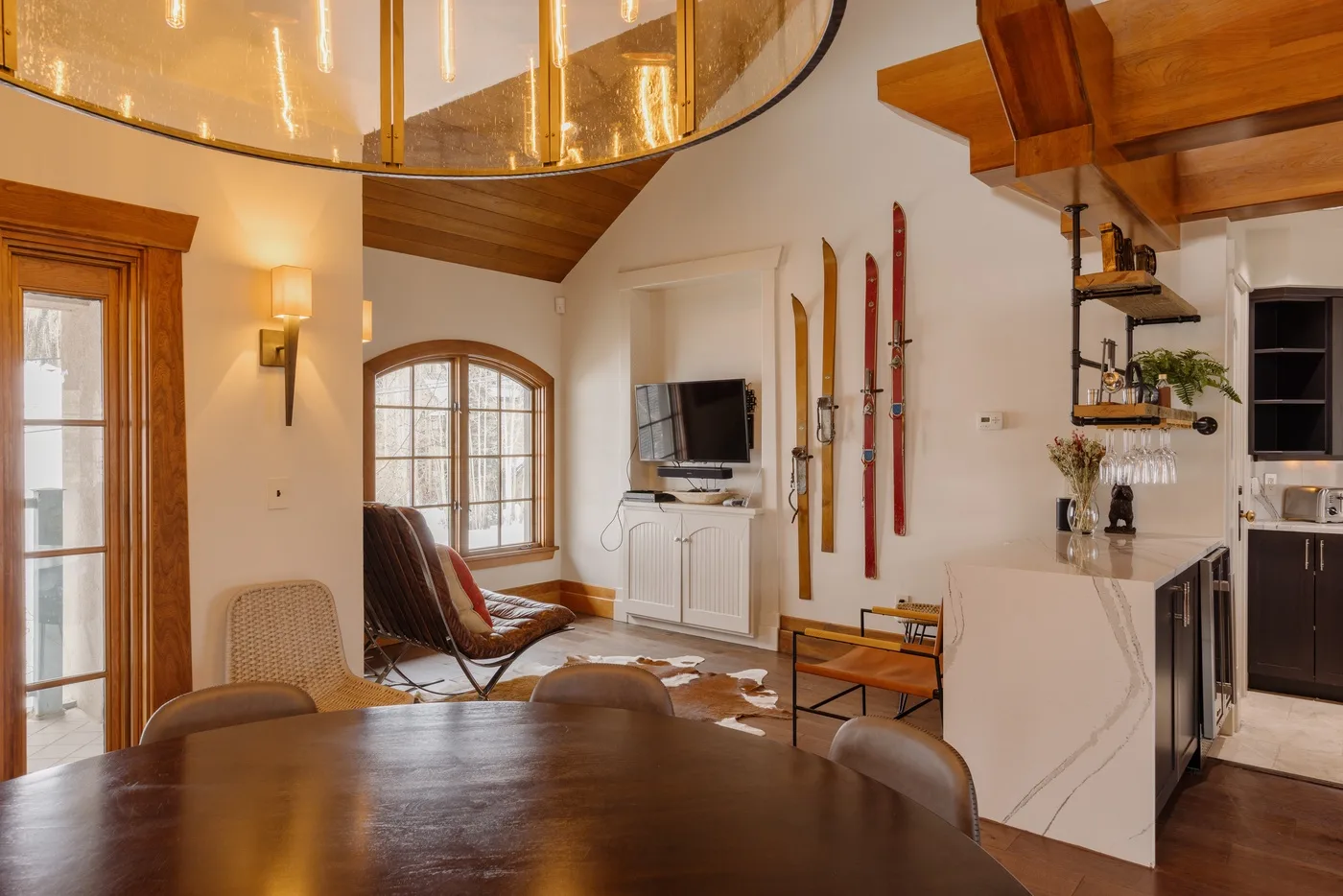 An open living and kitchen area with a dining table and tall windows.