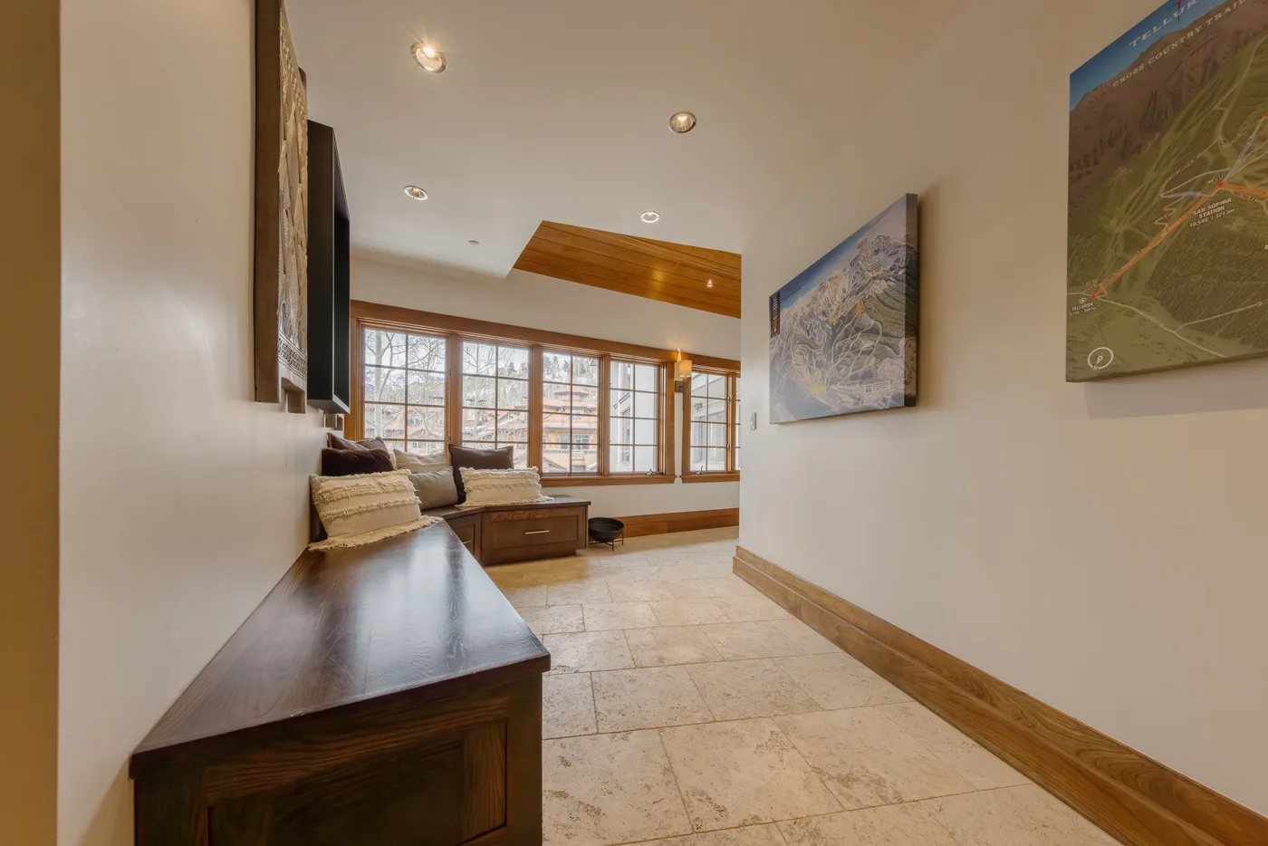 A bright lounge with a seating area, wooden tables, and large windows.