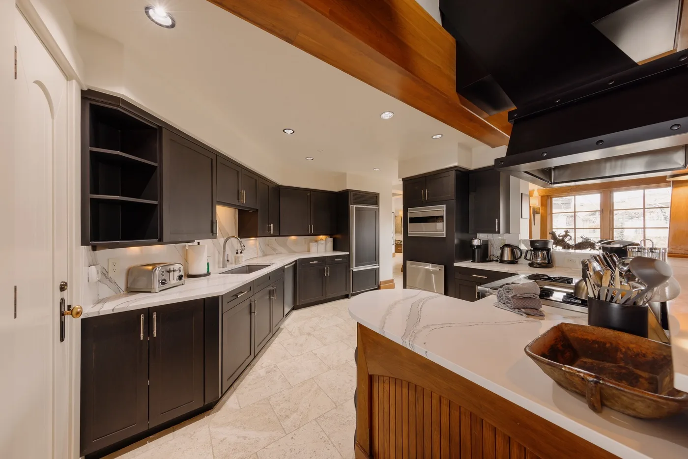 A spacious kitchen with dark cabinets, a light countertop, and a central island.