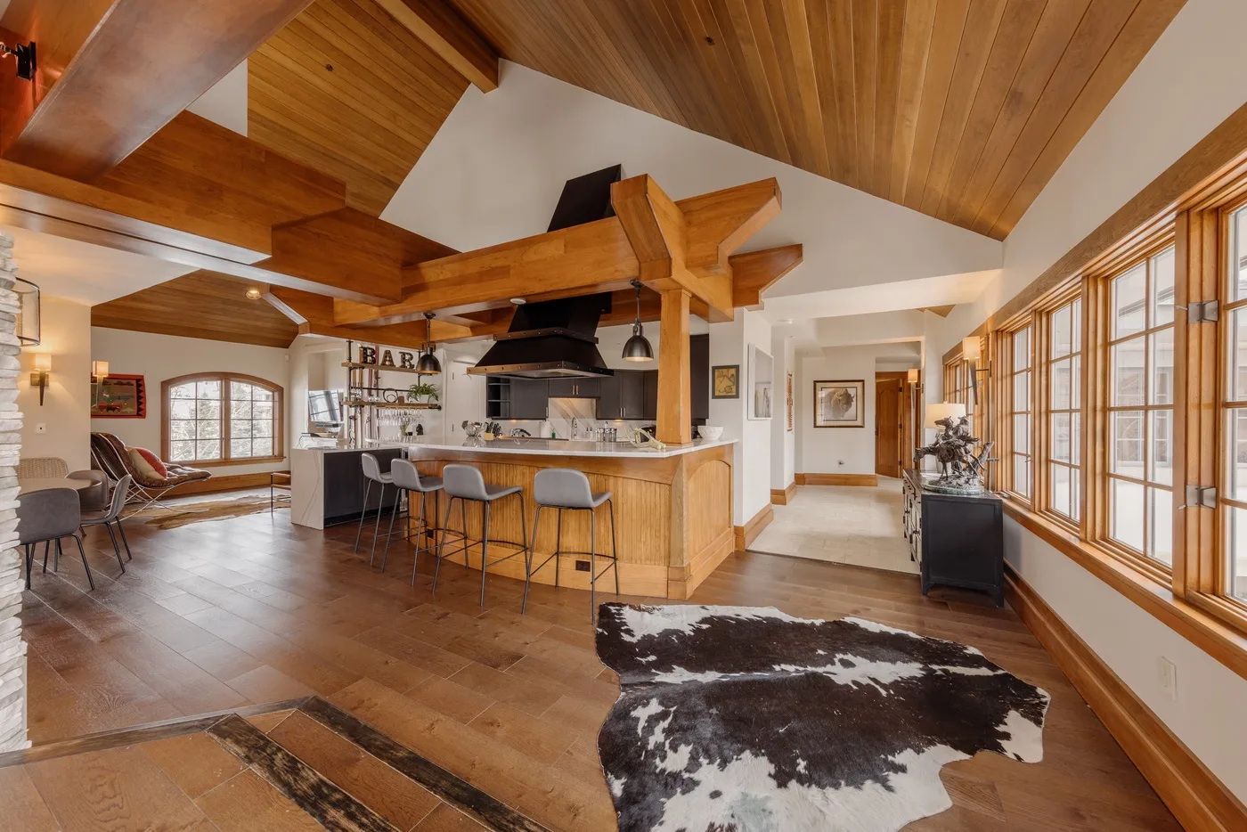 A spacious kitchen and dining area features a wood island beneath exposed timber beams.