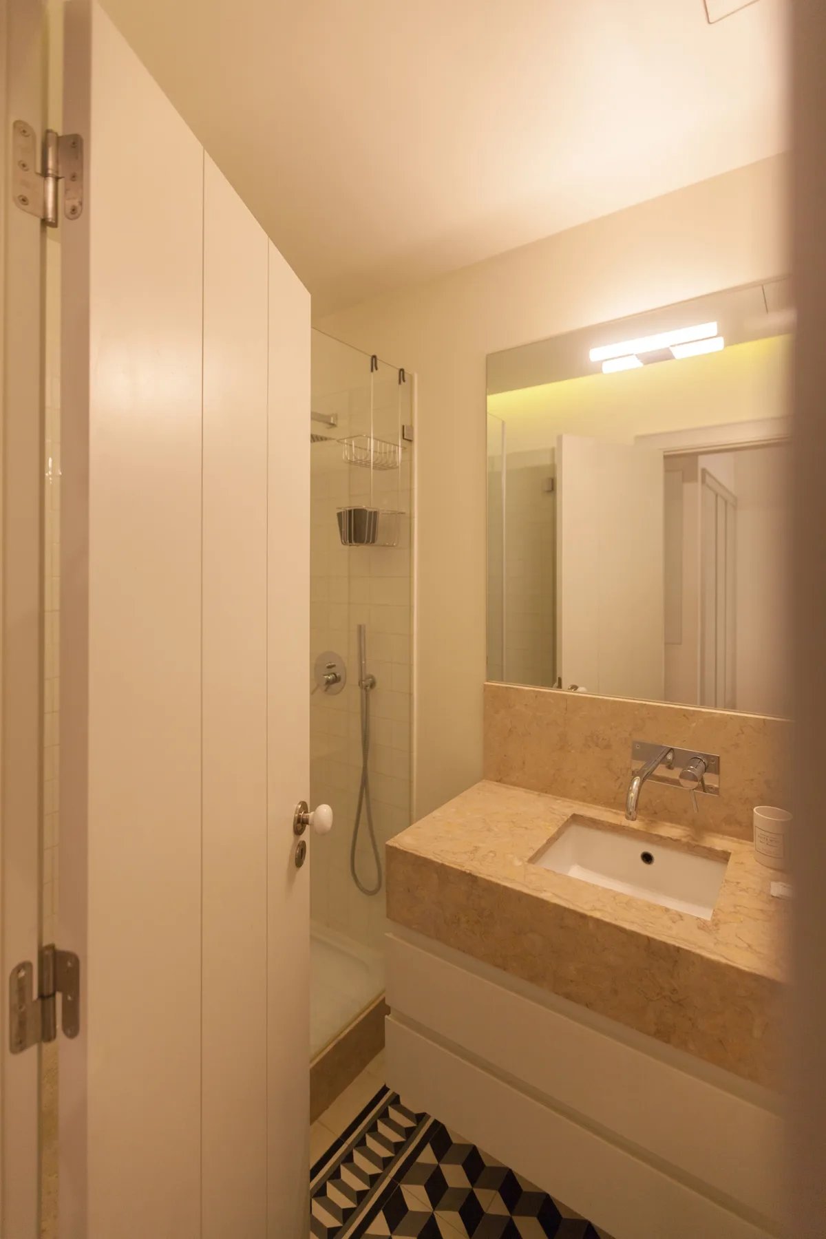 Baño con ducha, lavabo y espejo.