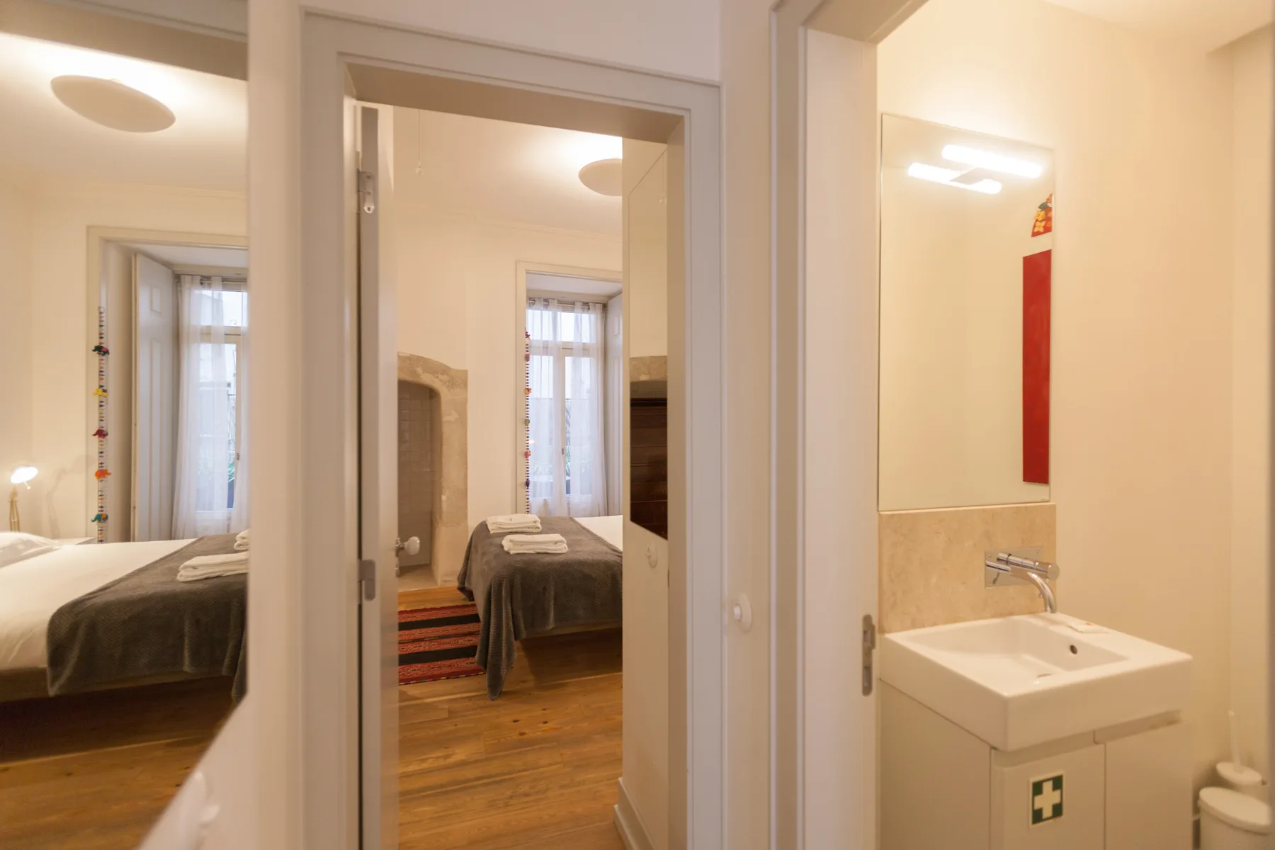 Un dormitorio con una cama y un lavabo en el baño contiguo.