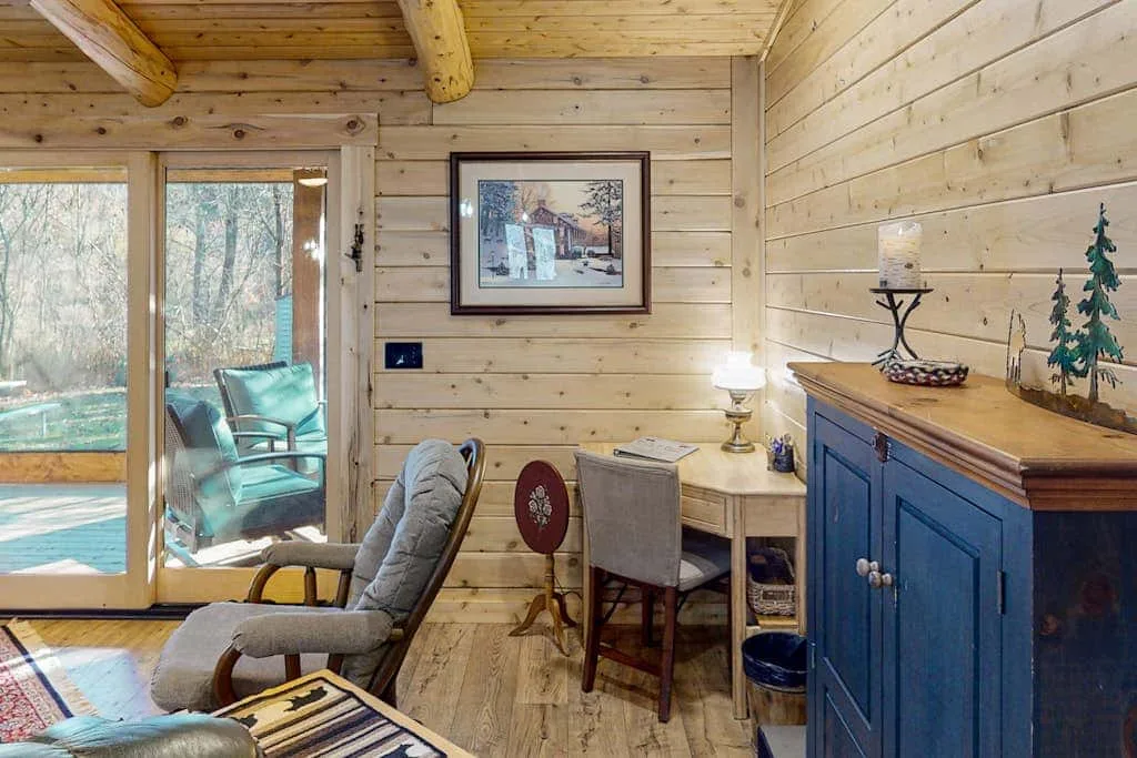 A wood-paneled sitting area with a glass door opening onto a deck.