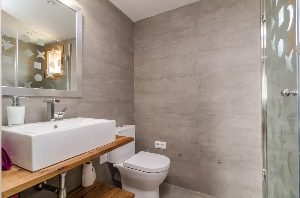Un baño con lavabo, inodoro y ducha de vidrio.