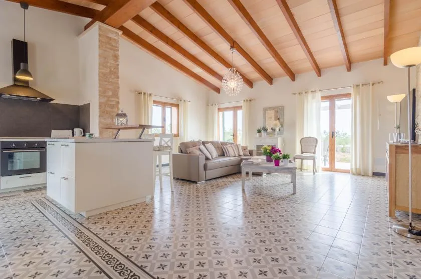 Una sala de estar y cocina de concepto abierto con vigas de madera a la vista.