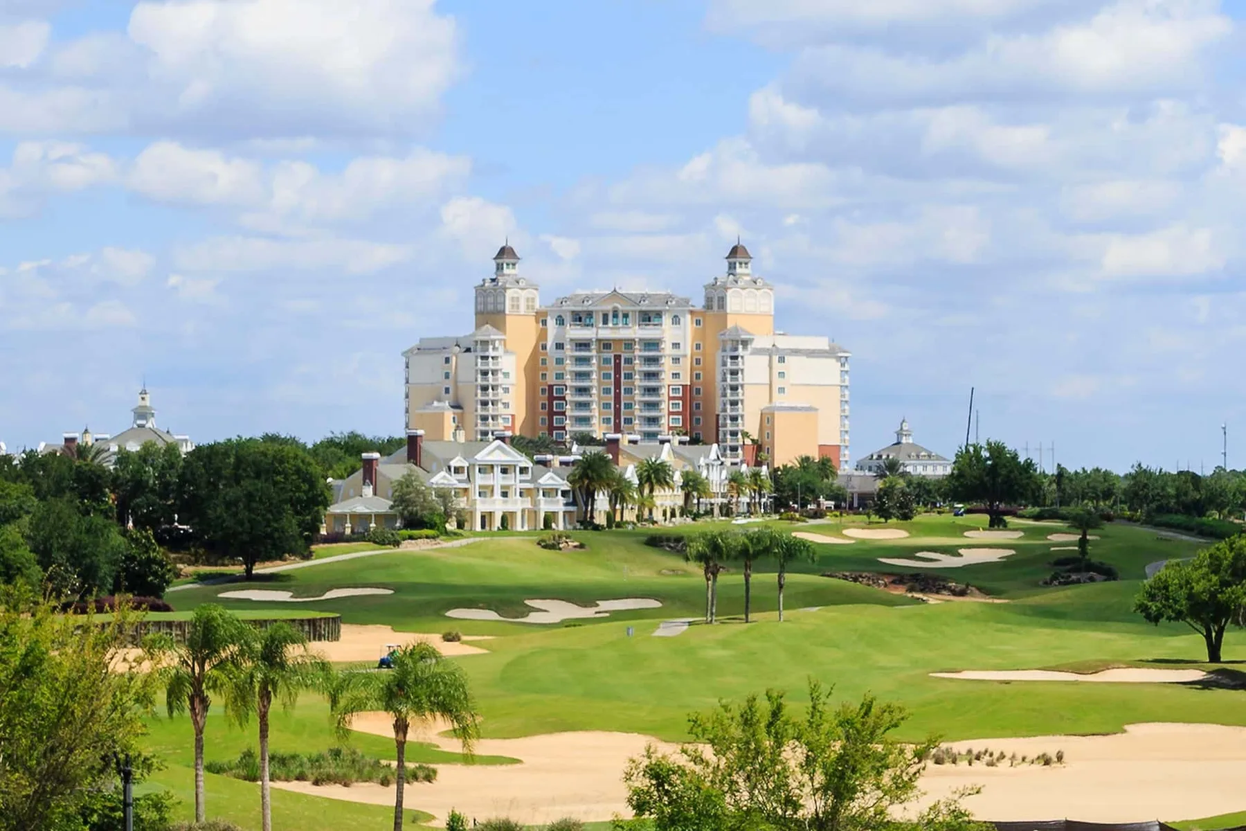 A golf course with a large resort building in the background.