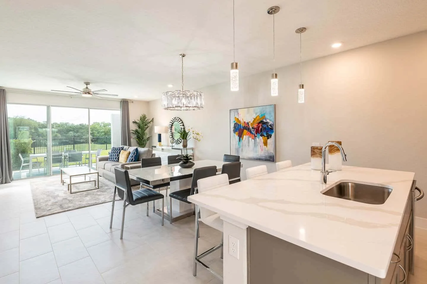 A bright open-plan living and dining area with a kitchen island and large windows.