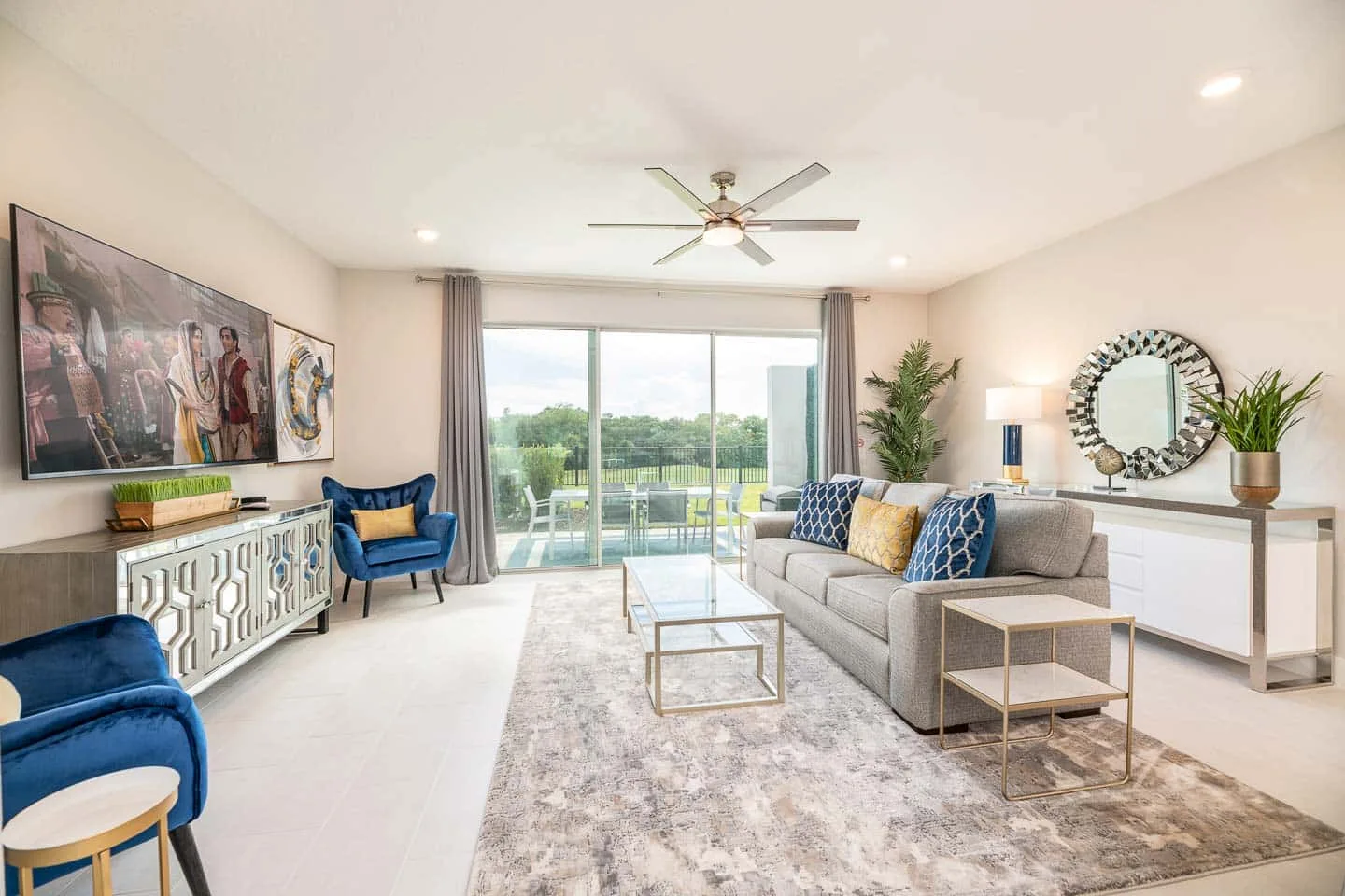 A bright living room with seating arranged around a coffee table beside sliding glass doors.