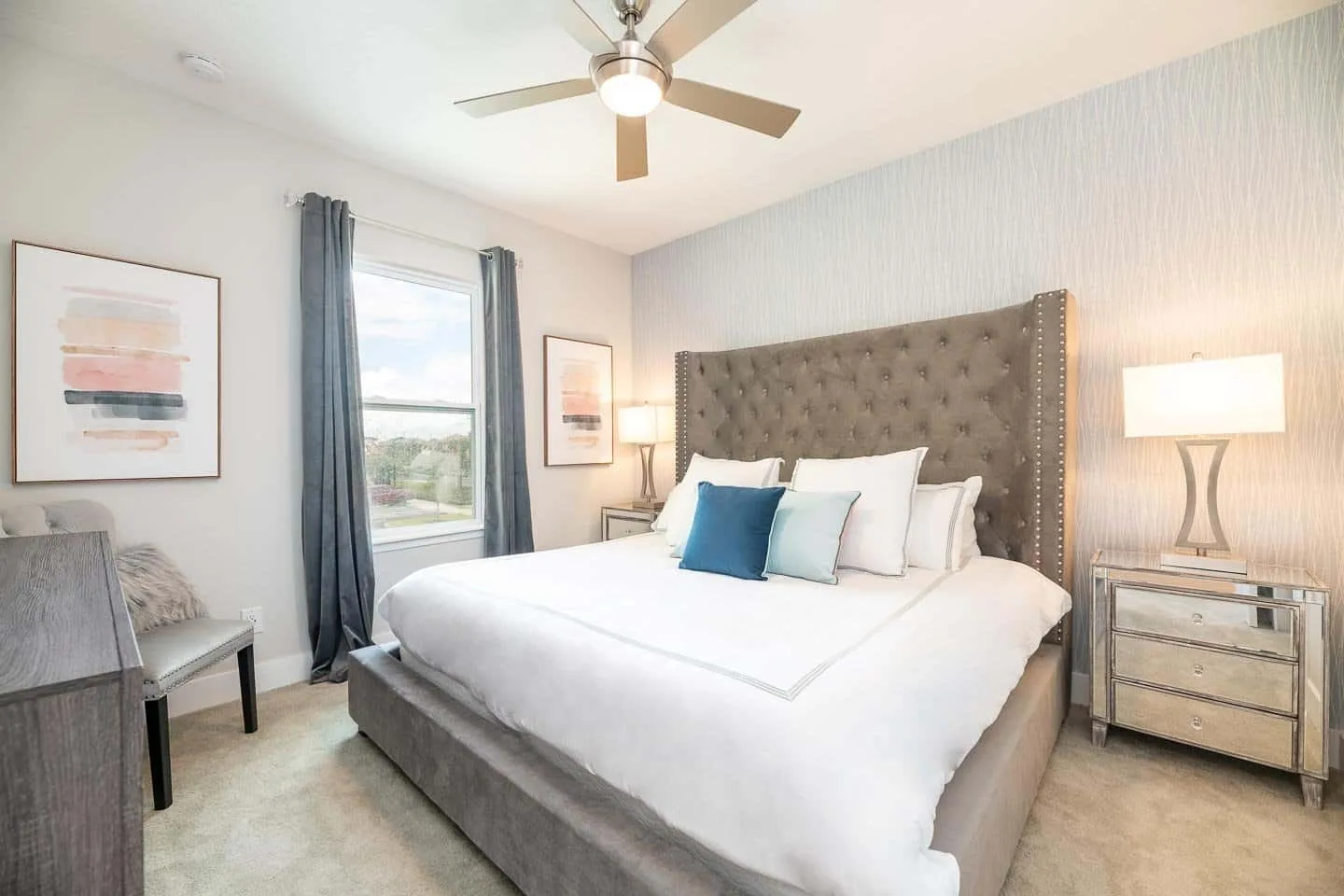 A bedroom with a large bed, upholstered headboard, and a window.