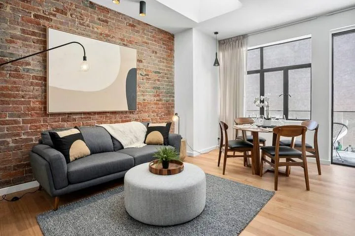 A living and dining area with a sofa, round coffee table, and dining table.