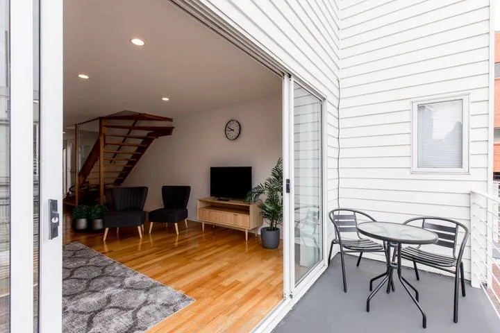 An open living area with seating, a television, and a patio table.