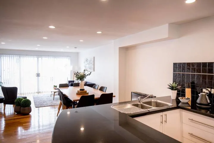 A bright open-plan kitchen and dining area with a large island and table.