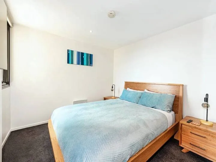 A bedroom with a wooden bed dressed in pale blue bedding.