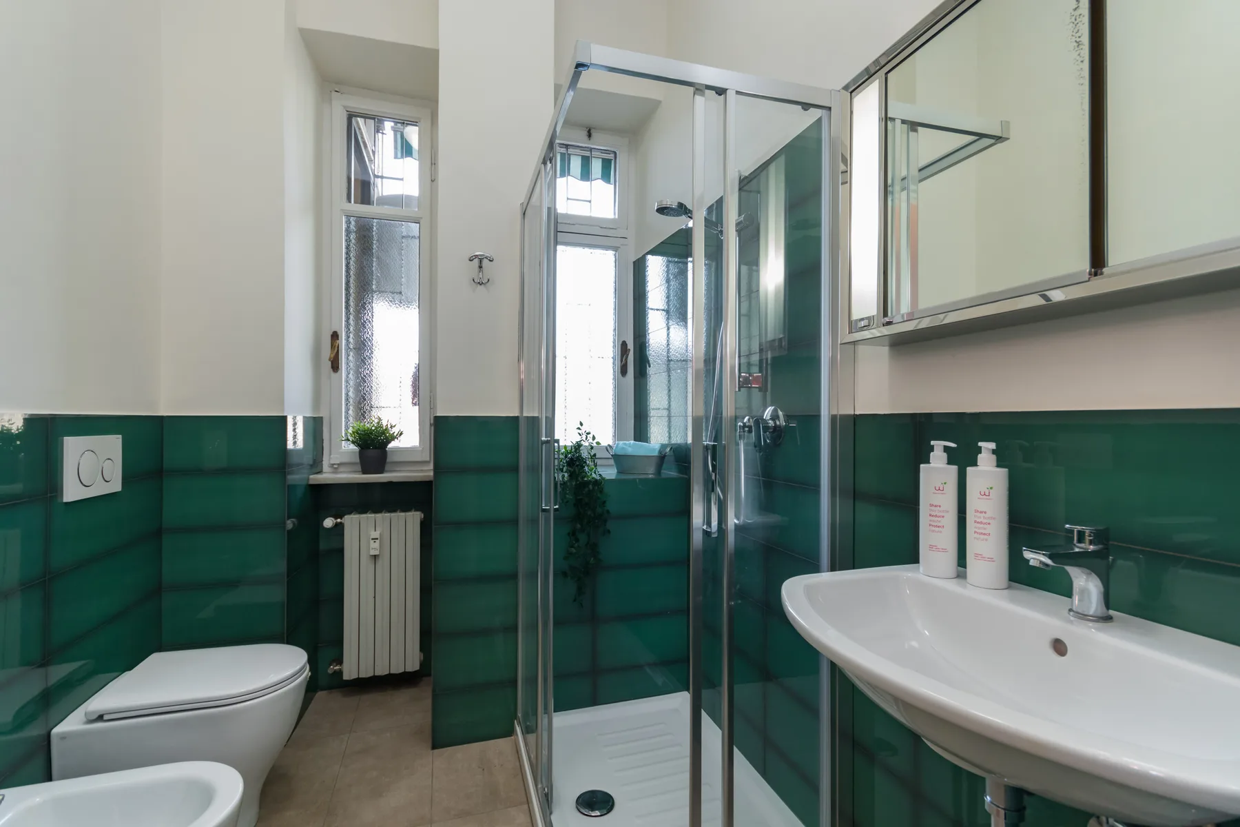 Un baño con ducha, inodoro y lavabo.